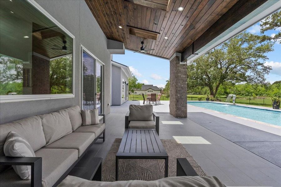 This expansive covered patio features a stunning stained-wood ceiling.