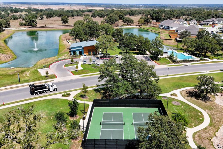Drone / aerial view of pickle-ball court, community pool & pond. Drone / aerial view of pickle-ball court, community pool & pond.