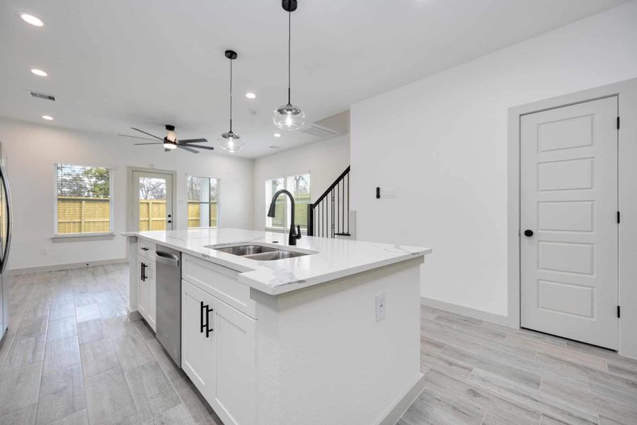 Open-concept layout connecting the kitchen seamlessly to the main living area, creating an ideal space for gatherings. Large windows bring in abundant natural light while highlighting the modern finishes throughout.