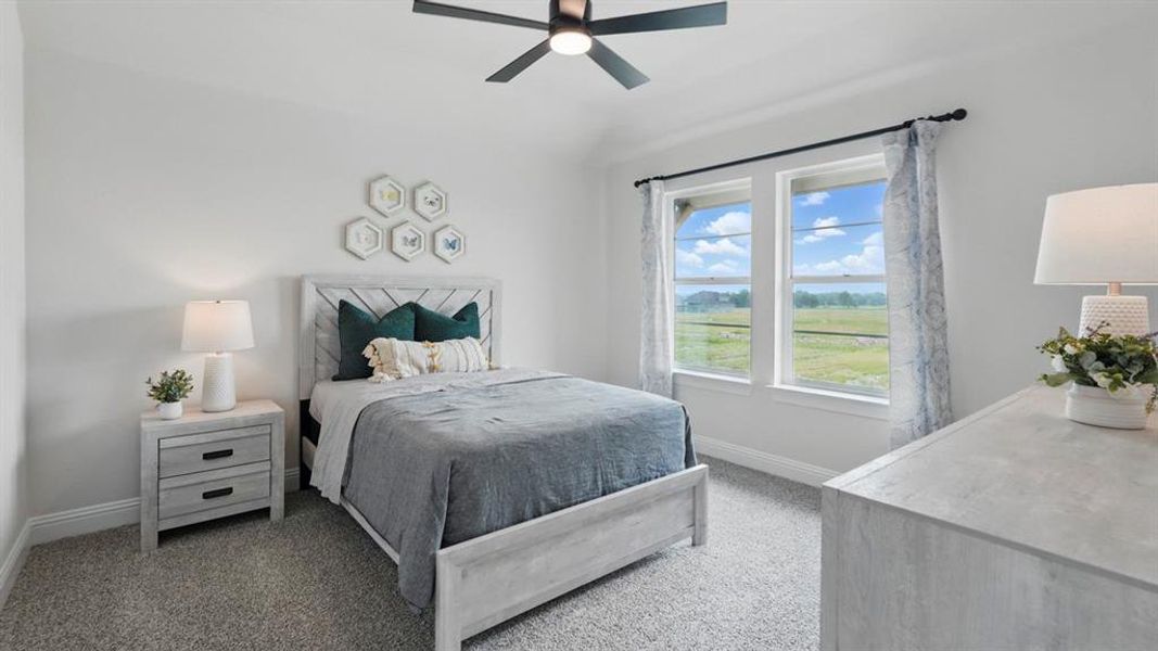 Carpeted bedroom featuring a vaulted ceiling with a ceiling fan, two windows with white trim, and a horizontal wood-slat headboard