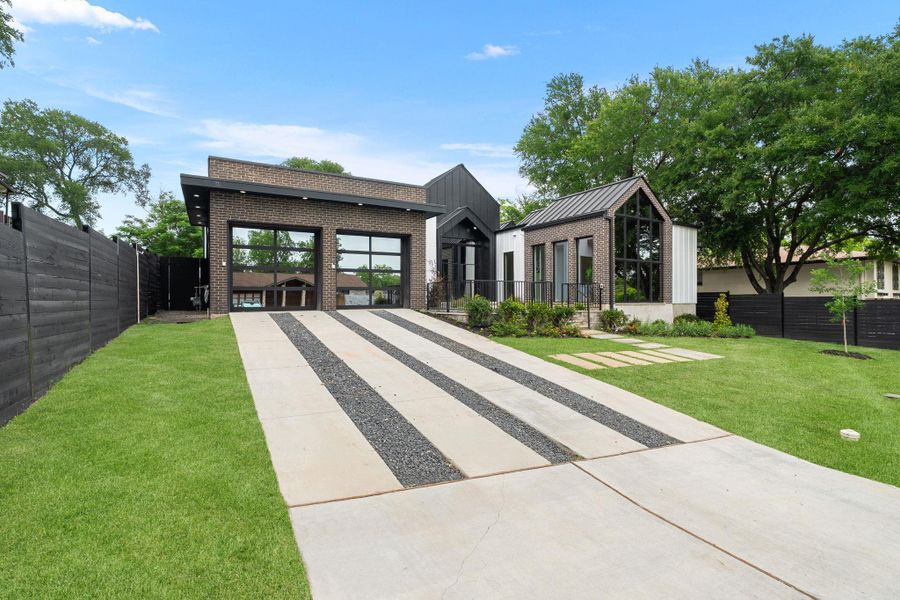 Contemporary exterior featuring dark brick, vertical white siding, and a standing seam metal roof