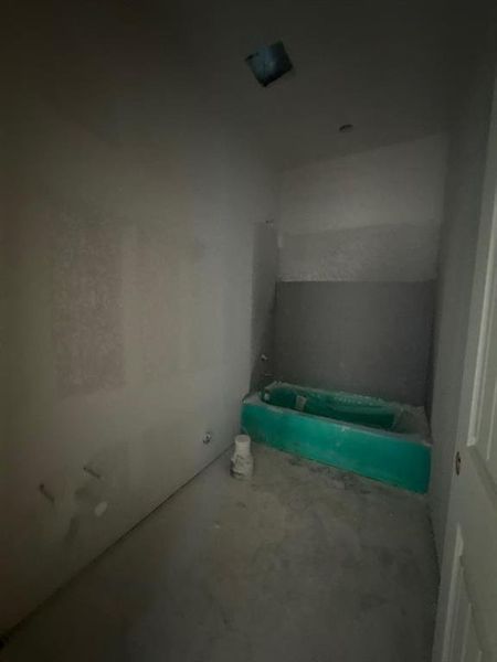 Full bath with a bathtub and unfinished concrete floors Full bath with a bathtub and unfinished concrete floors