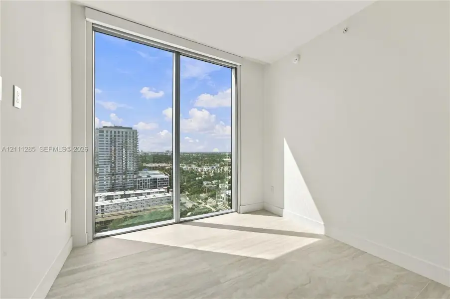 Floor-to-ceiling windows, neutral interior walls, and light-toned tile flooring Floor-to-ceiling windows, neutral interior walls, and light-toned tile flooring