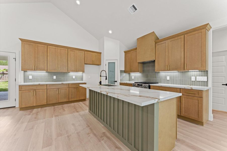 The kitchen is equipped with a 5 burner gas range with custom hood vent, under-counter microwave, soft close cabinet and drawers and a 9' island that can easily seat 4.