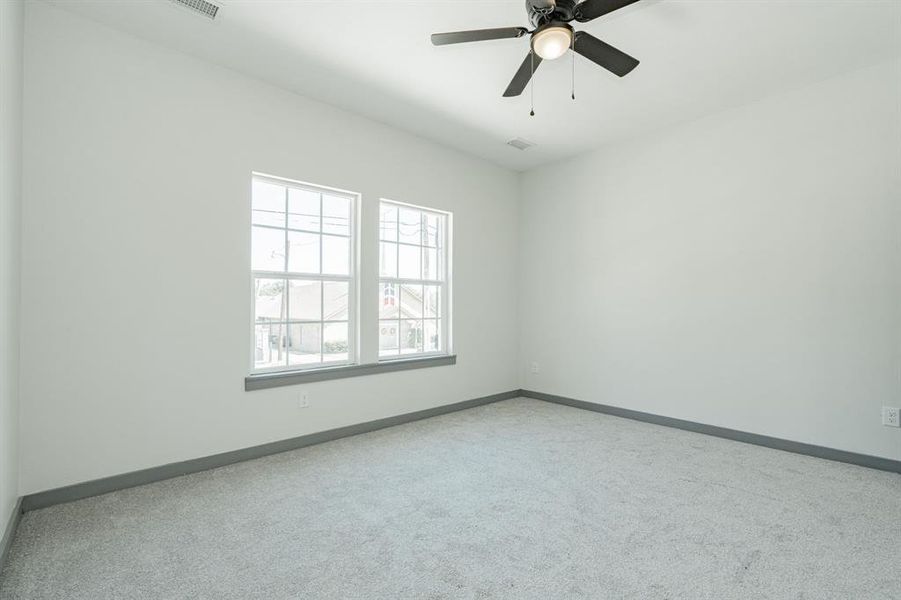 Carpeted empty room with ceiling fan