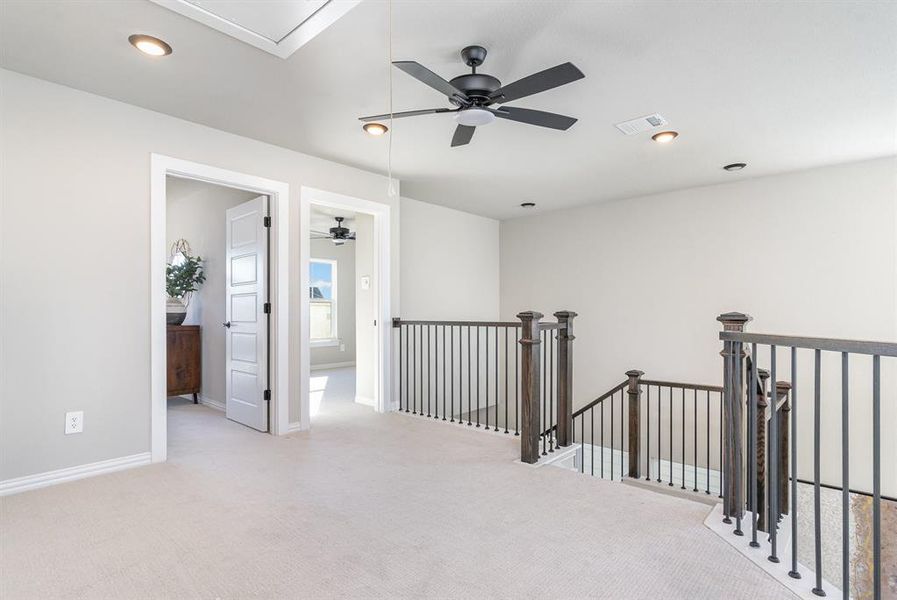 Corridor featuring light colored carpet