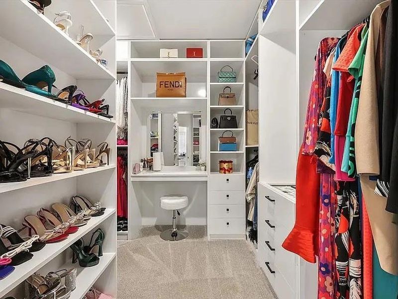 Walk in closet with light colored carpet