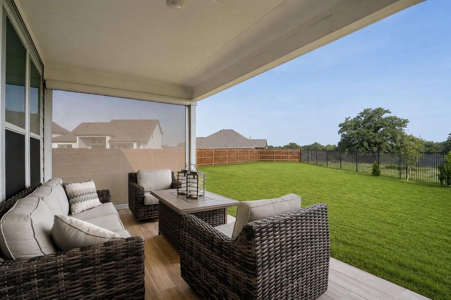 A spacious covered patio provides a delightful outdoor living space with expansive backyard views. A spacious covered patio provides a delightful outdoor living space with expansive backyard views.