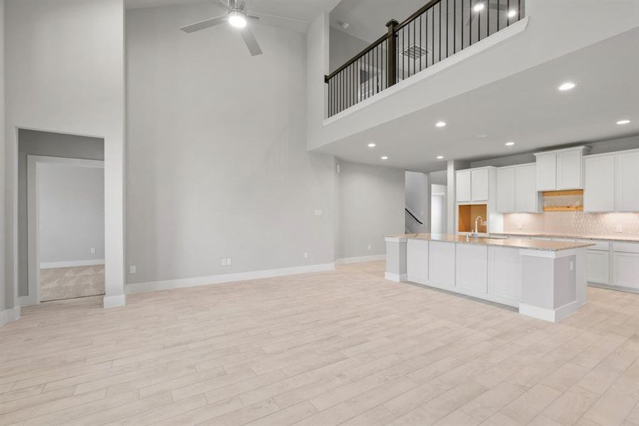 Take another glimpse into the heart of the home with this additional view of the family room—a sprawling space ready to accommodate all your gatherings. Sample photo of completed home with similar floor plan. Actual colors and selections may vary.