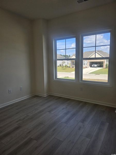 Spare room featuring dark wood-style floors