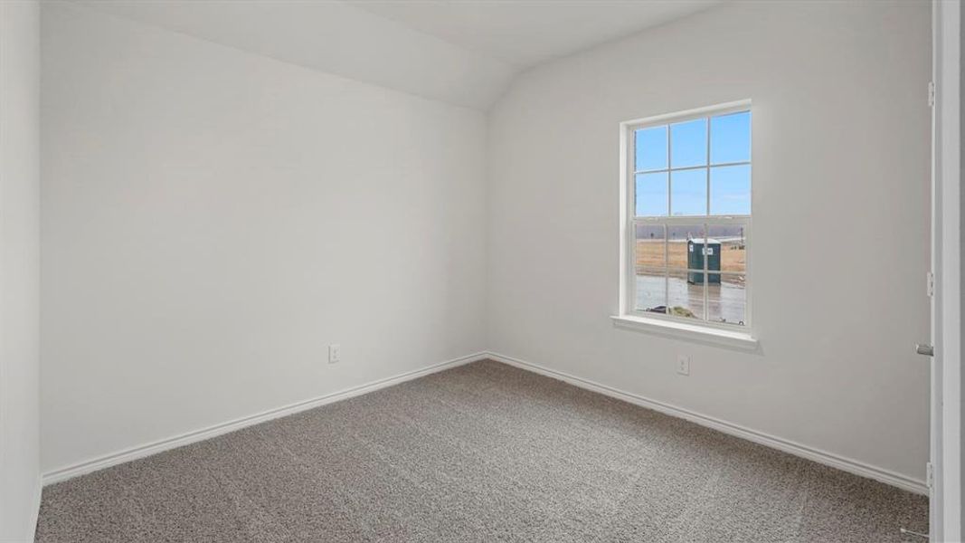 White-painted interior room featuring gray carpeting, a single window with white trim, and a white interior door