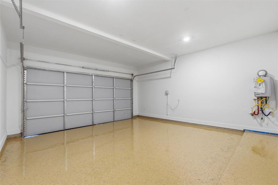 Epoxy flooring in the two-car garage, with easy access to the sprinkler system control panel and tankless water heater.