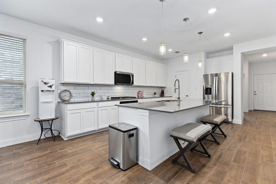 Culinary creations come to life in this kitchen, featuring an expansive island with a breakfast bar.