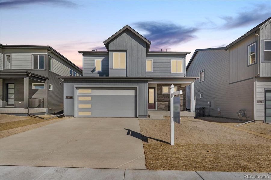 Front exterior of a new home in Portrait at The Canyons, Castle Pines, CO, highlighting curb appeal (Image 1).