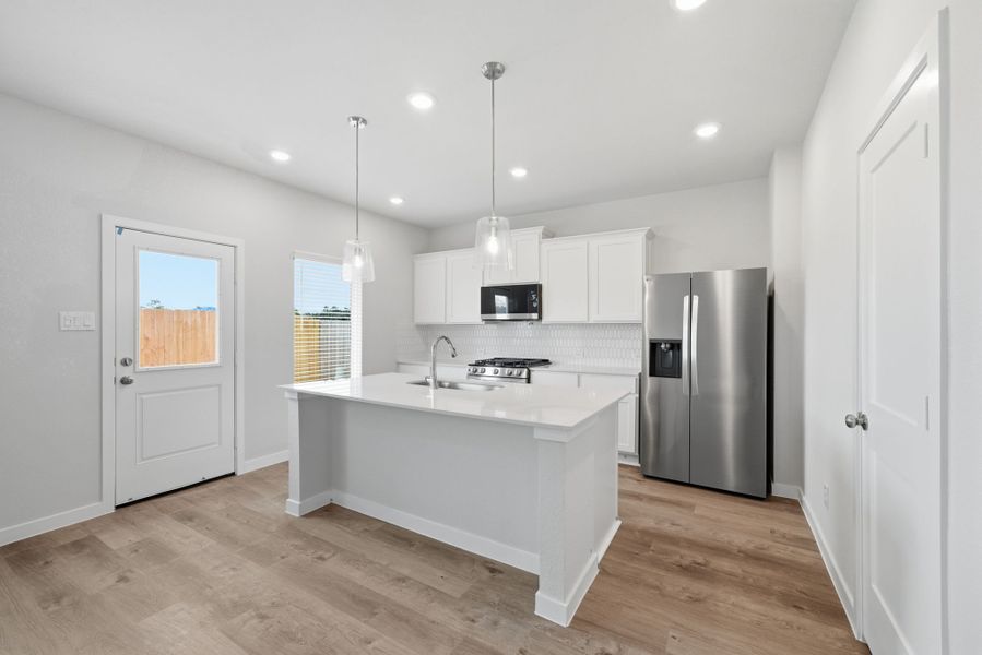A kitchen with white cabinets.