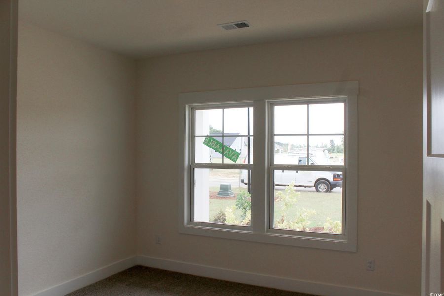 Empty room with baseboards and dark carpet
