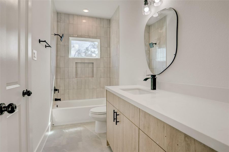 The 2nd full bath has quartz counters and a tub/shower combo with tile surround.