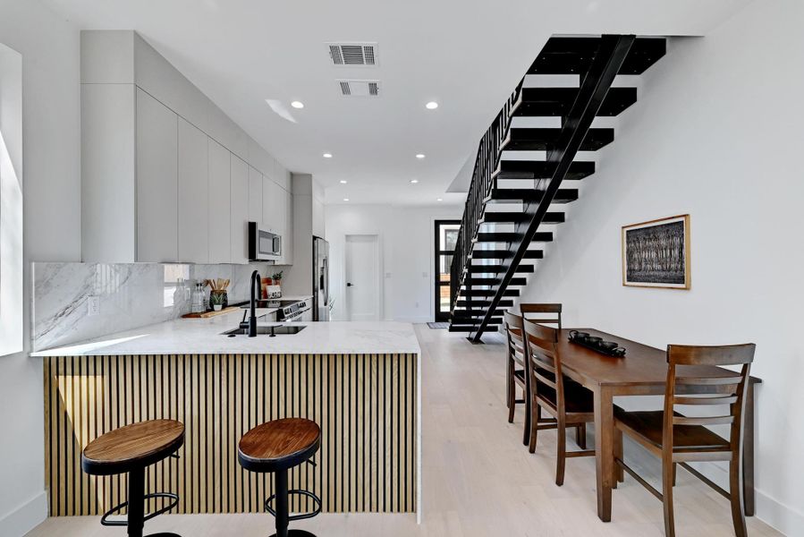 Kitchen featuring  a peninsula, stainless steel appliances, and backsplash