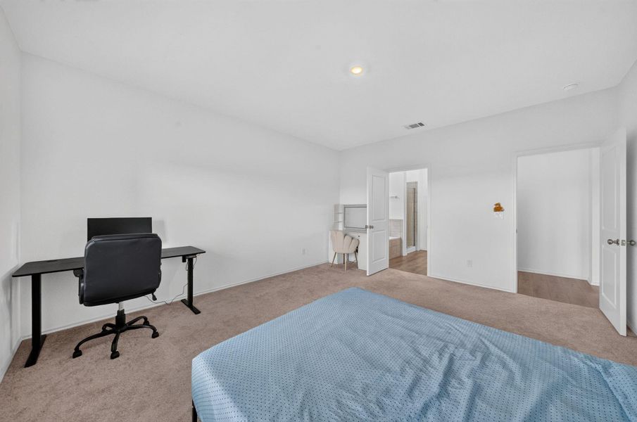 A well-lit bedroom provides ample space for rest and productivity with plush carpeting and modern doors leading to a private bath. A well-lit bedroom provides ample space for rest and productivity with plush carpeting and modern doors leading to a private bath.