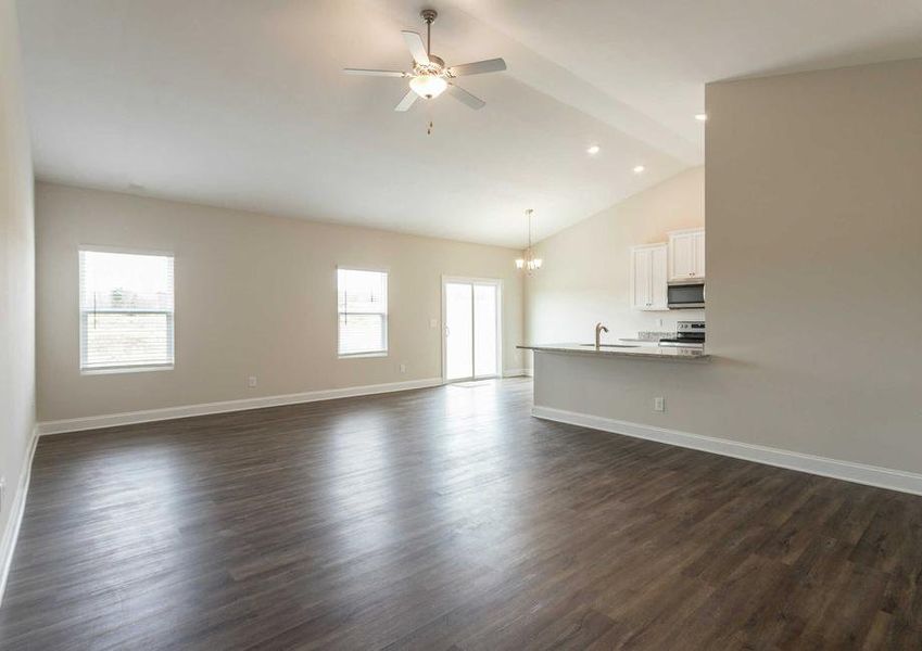 Alexander great room with wood look flooring, white trim, and vaulted ceilings