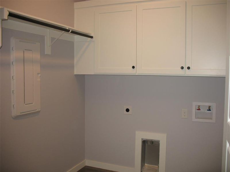 Washroom with cabinet space, electric panel, washer hookup, hookup for an electric dryer, and dark wood-style floors