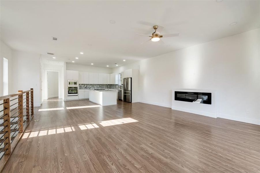 Unfurnished living room with light wood-type flooring, recessed lighting, and ceiling fan Unfurnished living room with light wood-type flooring, recessed lighting, and ceiling fan