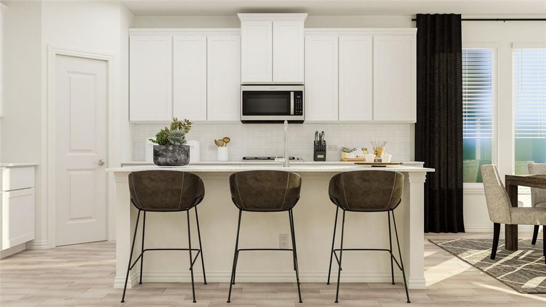 Kitchen featuring light hardwood / wood-style flooring, tasteful backsplash, an island with sink, white cabinets, and a breakfast bar area