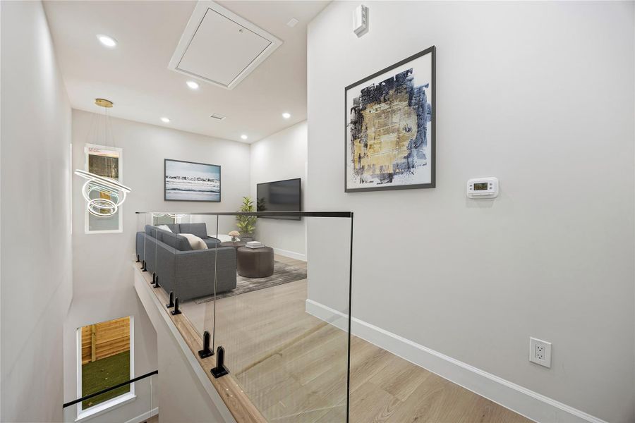 Hall with attic access, recessed lighting, and wood finished floors