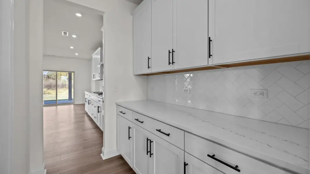 Norris Design pass-through butler's pantry with abundant cabinets. At Lakeside Glen by DRB Homes in York, SC. Norris Design pass-through butler's pantry with abundant cabinets. At Lakeside Glen by DRB Homes in York, SC.