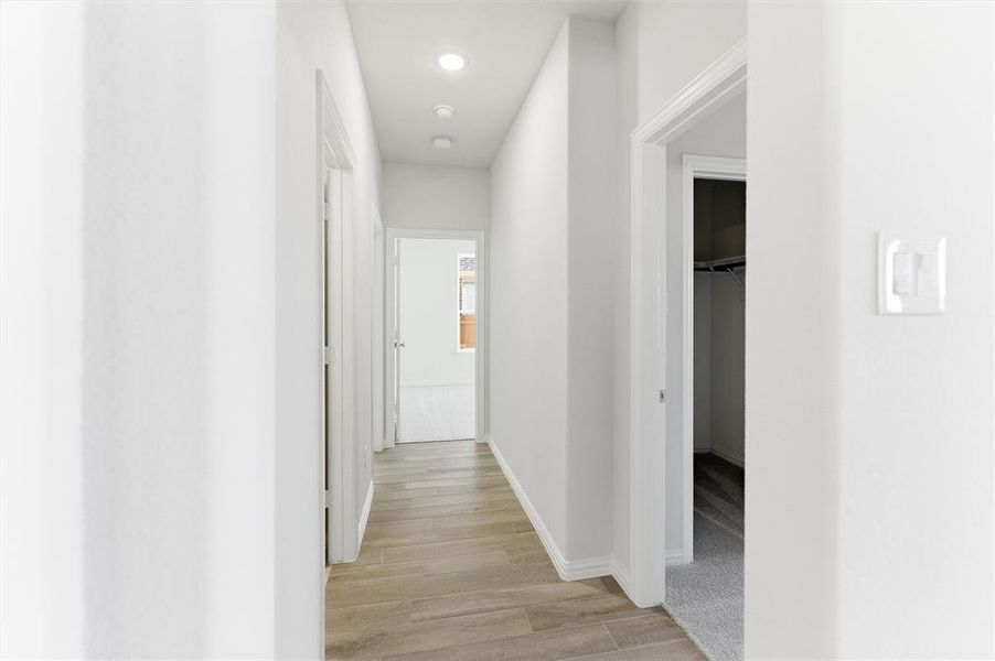 Hall with light wood-style floors and recessed lighting