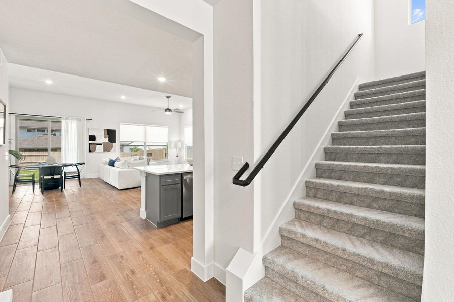 Staircase view featuring upgraded paint-grade round wood balusters, straight wrought iron detailing, and black stained stair finish. Staircase view featuring upgraded paint-grade round wood balusters, straight wrought iron detailing, and black stained stair finish.