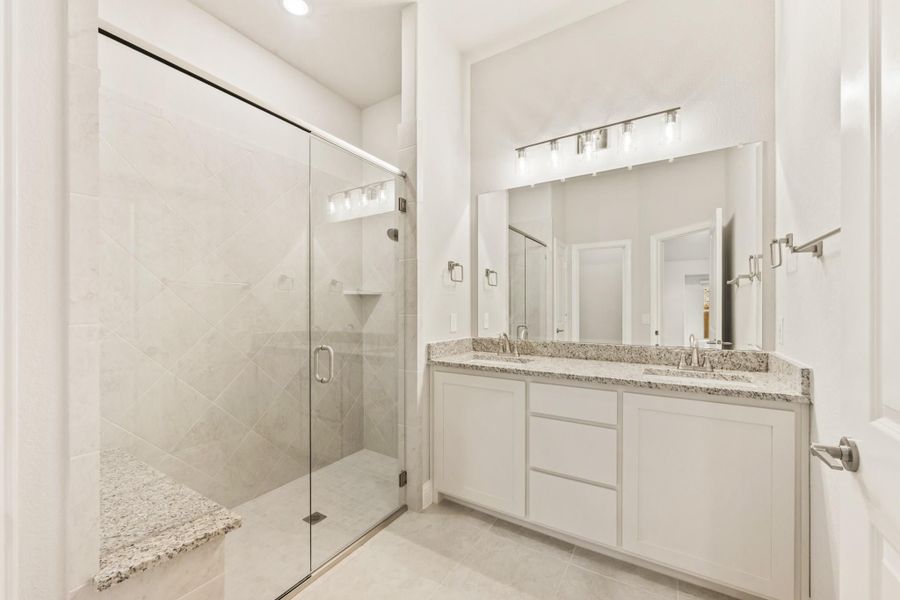 Bathroom with glass walk-in shower, double vanity, granite countertops, and white cabinets Bathroom with glass walk-in shower, double vanity, granite countertops, and white cabinets