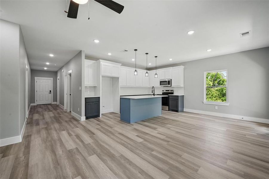 Kitchen featuring appliances with stainless steel finishes, a sink, recessed lighting, a center island, and ceiling fan