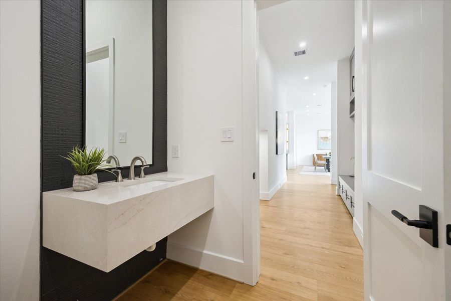Stylish powder bath with floating quartz vanity and accent wall. Stylish powder bath with floating quartz vanity and accent wall.