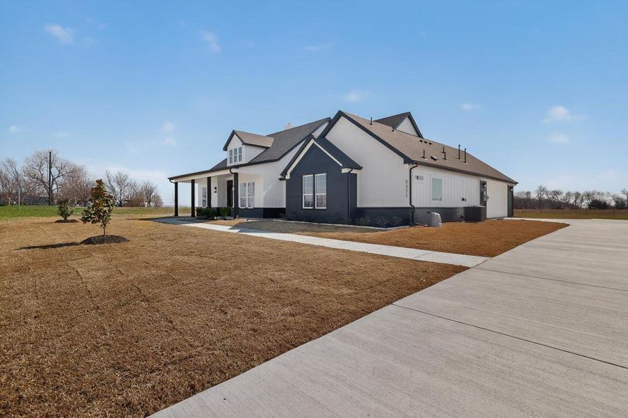 View of home's exterior featuring a porch, a lawn, and stucco siding