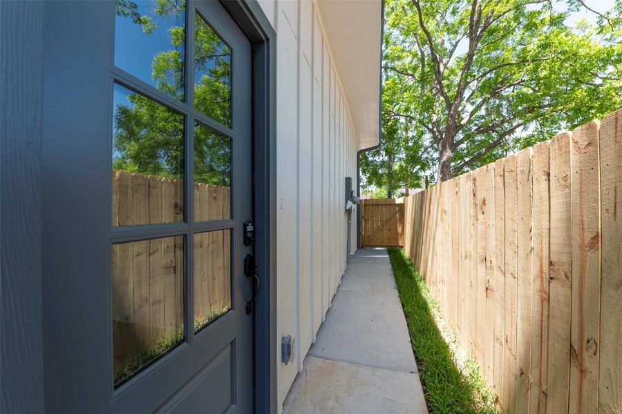 Private side yard with a clean concrete pathway leading directly to the front door, offering convenient access and a functional outdoor corridor.