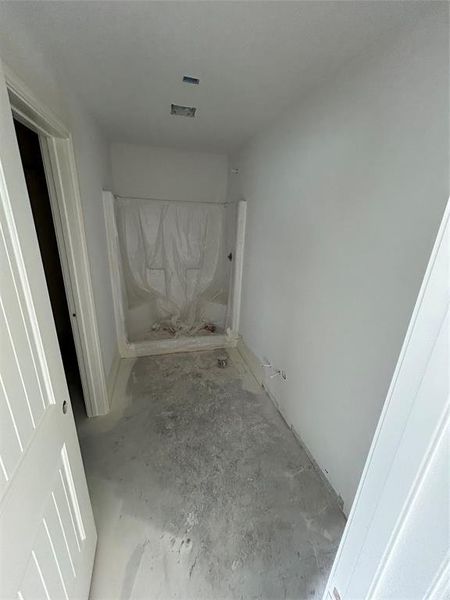 Full bathroom featuring a shower and unfinished concrete floors