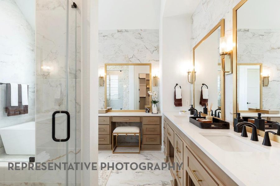 Full bathroom with double vanity, marble finish floor, a stall shower, and a sink