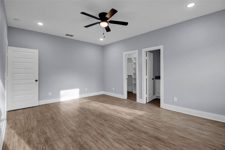 Unfurnished bedroom with recessed lighting, a walk in closet, ceiling fan, and wood finished floors
