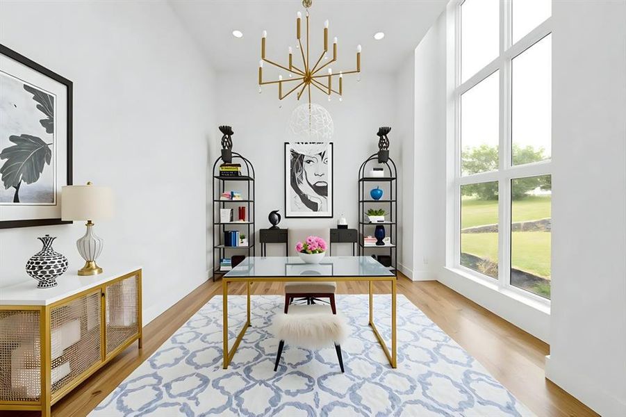 Virtually Staged Home office with a high ceiling, a chandelier, wood finished floors, and baseboards Virtually Staged Home office with a high ceiling, a chandelier, wood finished floors, and baseboards