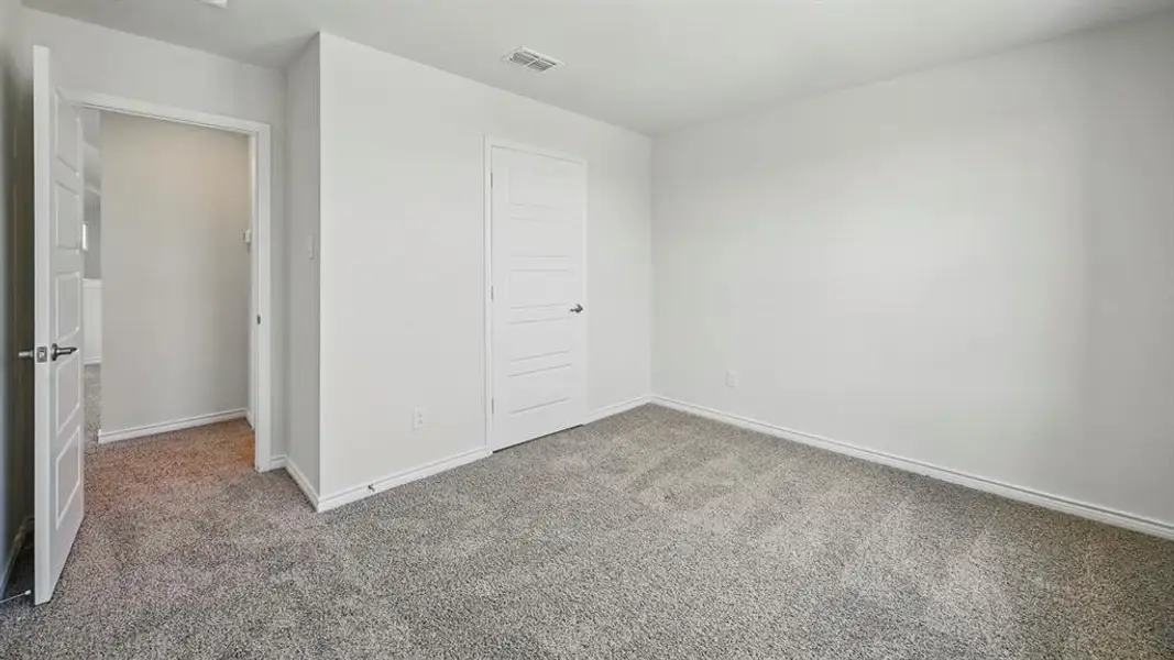 Interior room featuring plush gray carpeting and neutral white wall tones Interior room featuring plush gray carpeting and neutral white wall tones