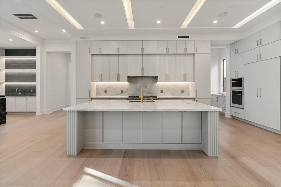 A true dream kitchen with many amenities: Spacious between back counter and island, Thermador appliance package, range with one full and one 1/2 oven, gas cook top, separate wall oven and microwave, extra storage under island, canceled coffee bar retractable cabinet, and SO much more!  NOTE: This photo is a rendering and not actual. Please contact the listing agent to tour this property and for more detailed information.