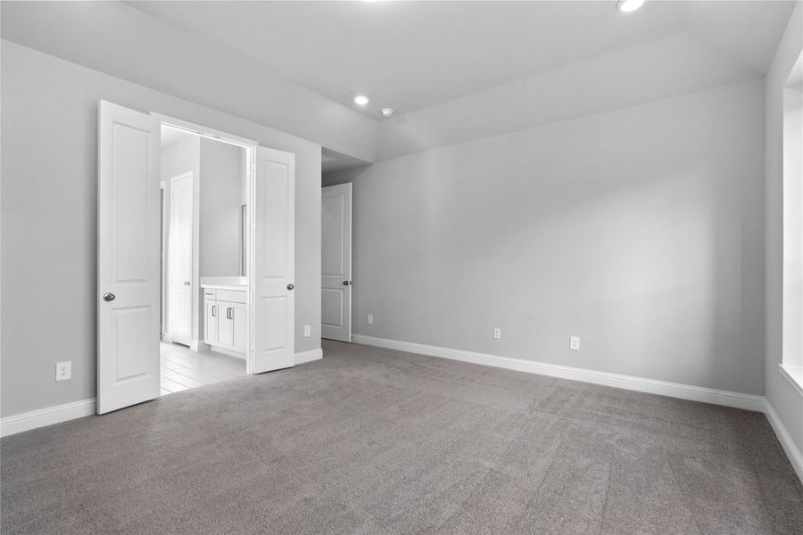 Additional view from primary bedroom looking towards the double door entrance to primary bathroom.