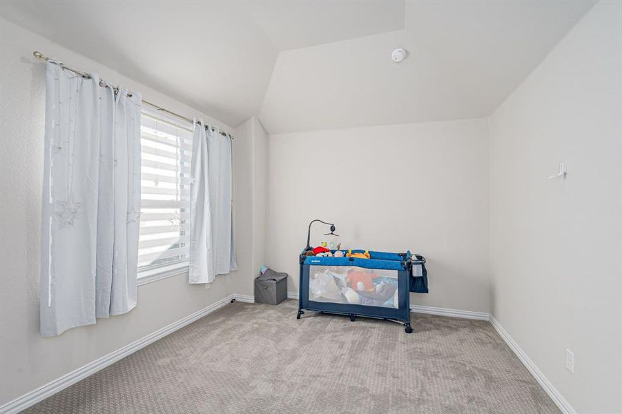 Playroom featuring light colored carpet and vaulted ceiling