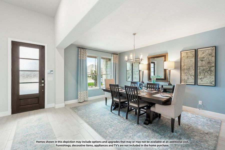 Dining room with dark wood table, chandelier, blue accent wall, and glass-panel front door visible nearby