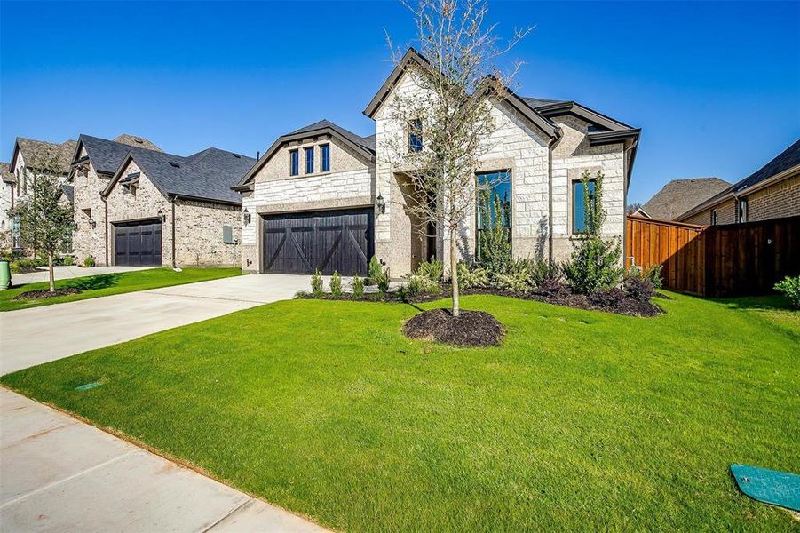 French country style house with a front yard and a garage