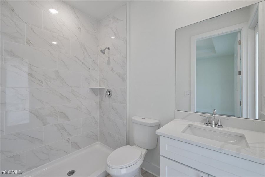 Full bathroom with vanity and a marble finish shower