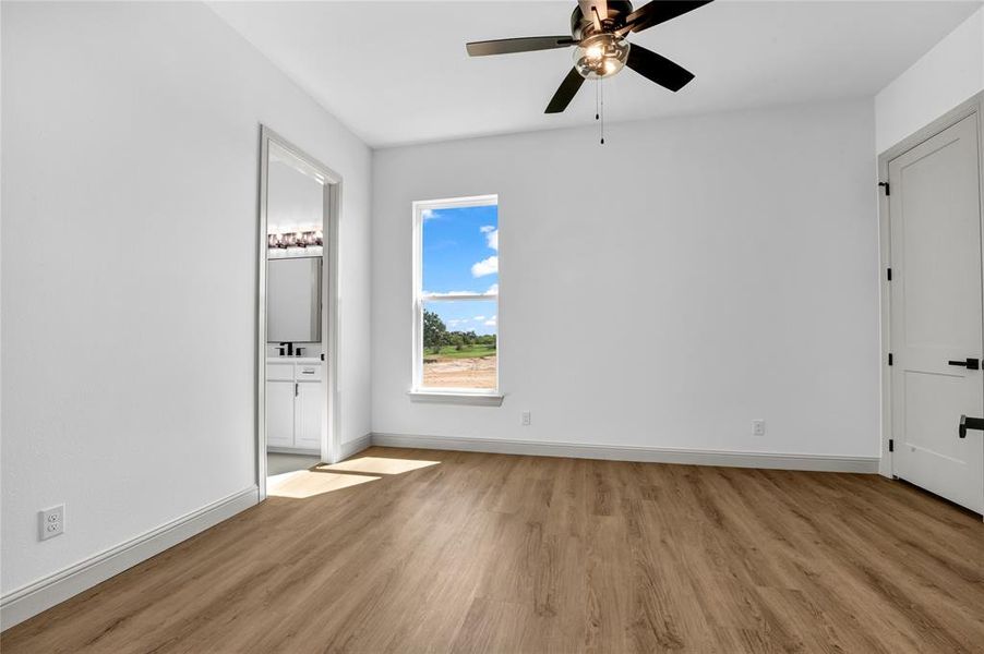 Unfurnished bedroom with ceiling fan, light hardwood / wood-style flooring, and connected bathroom