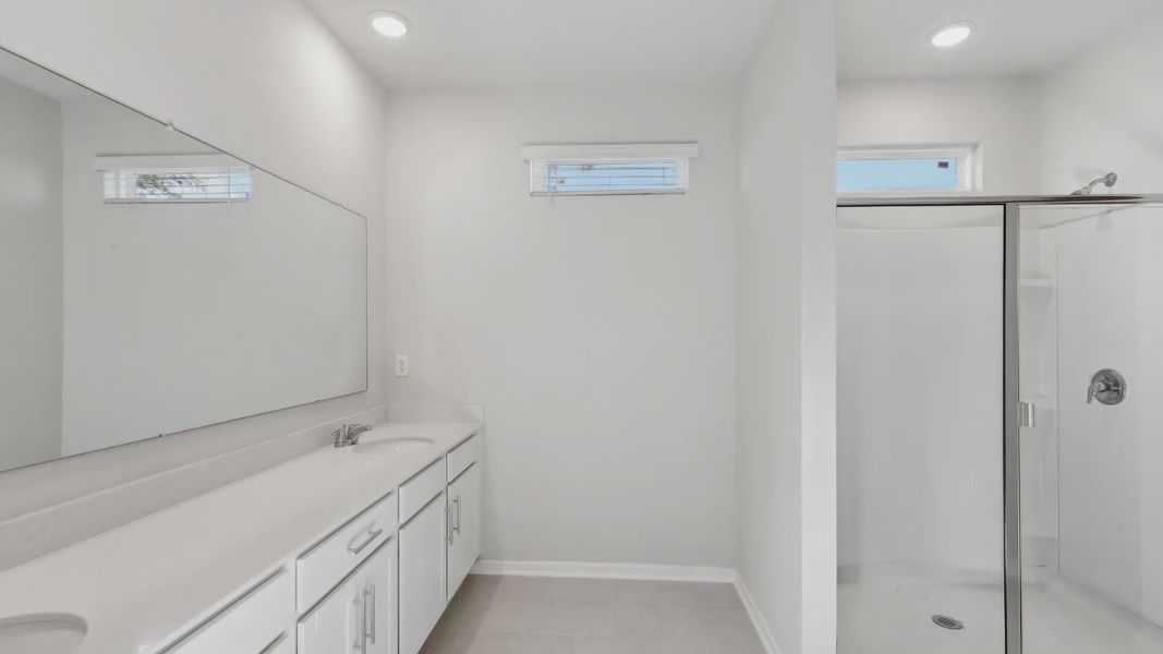 Experience refined luxury with dual sinks and pristine glass shower in this Palm Coast residence.