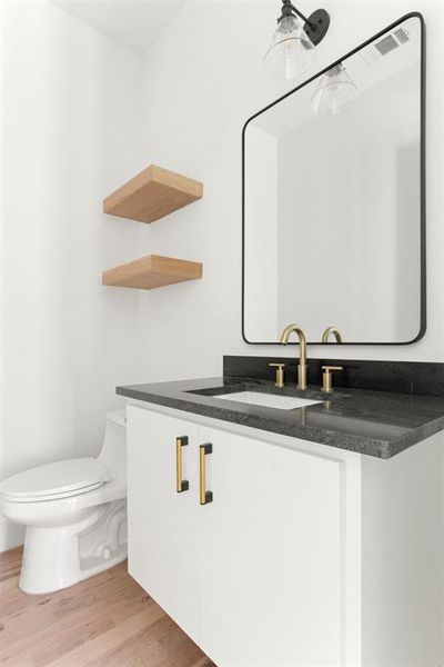 Bathroom featuring hardwood / wood-style floors, vanity, and toilet